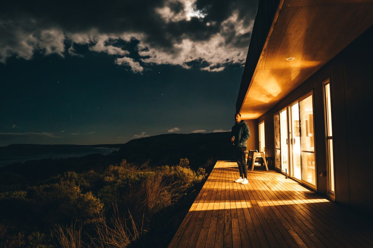 A cabin deck glowing warm under a night sky