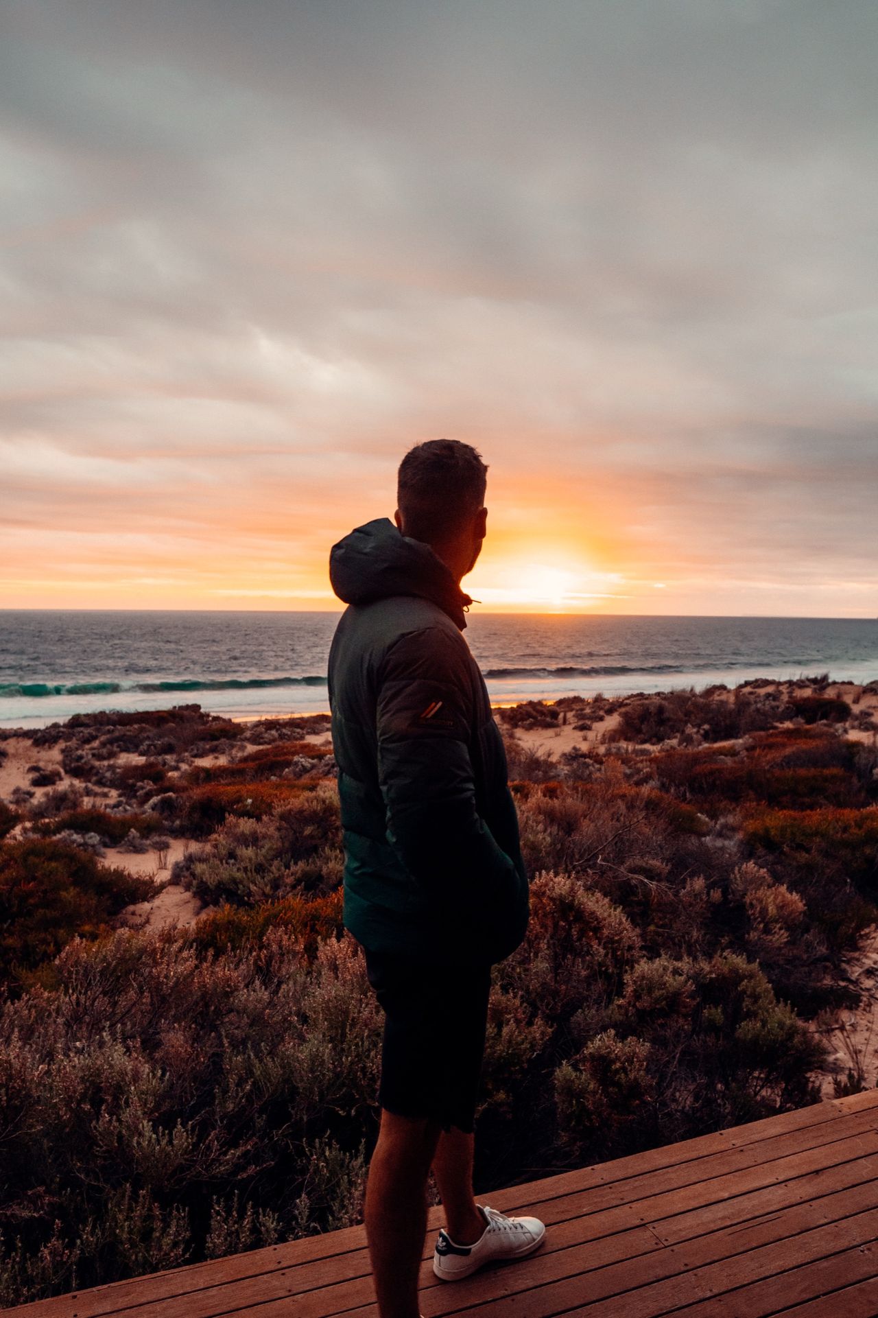 Luke Bakhuizen silhouetted at sunset on a deck