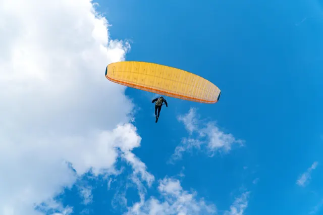 A paraglider against a deep blue sky