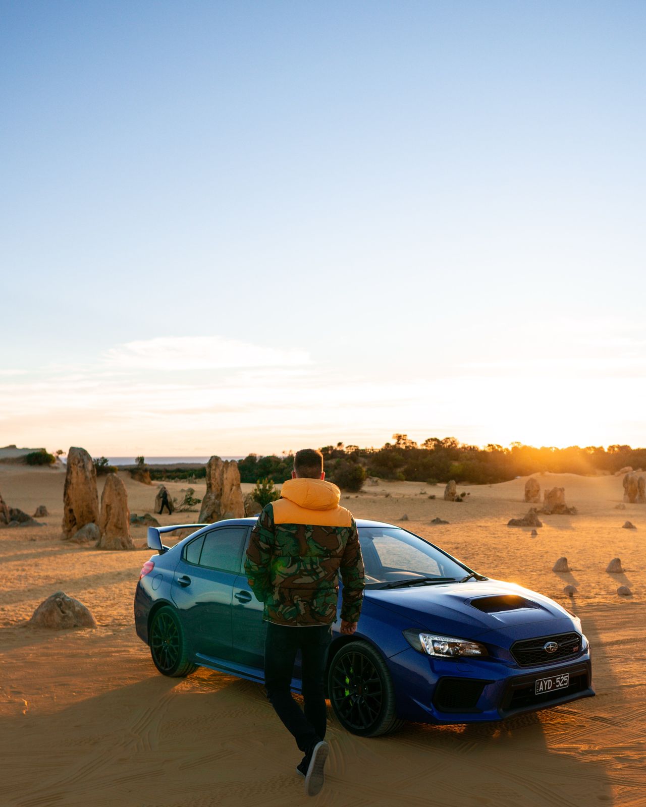 A Subaru WRX among limestone pinnacles at sunset